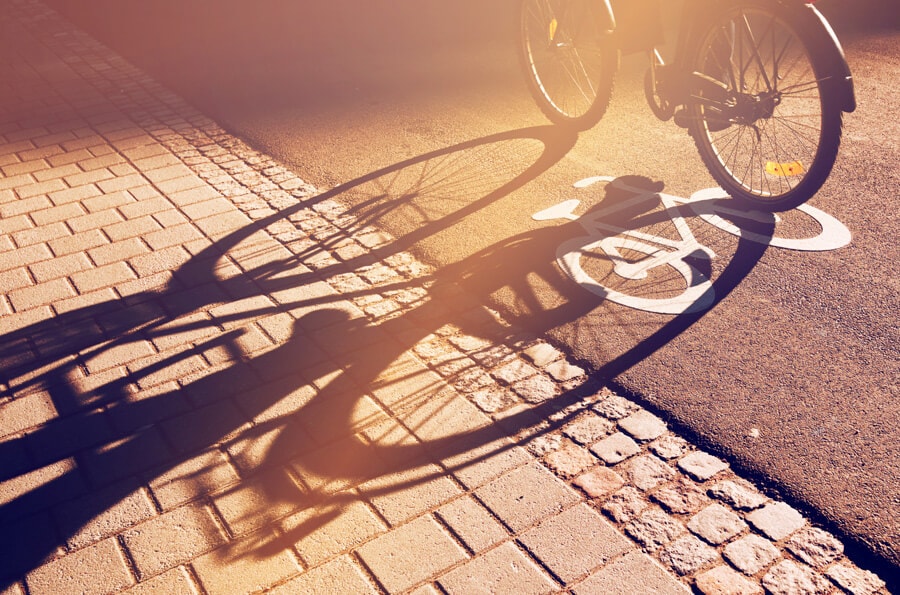 bicicleta na ciclovia fazendo sombra no asfalto.