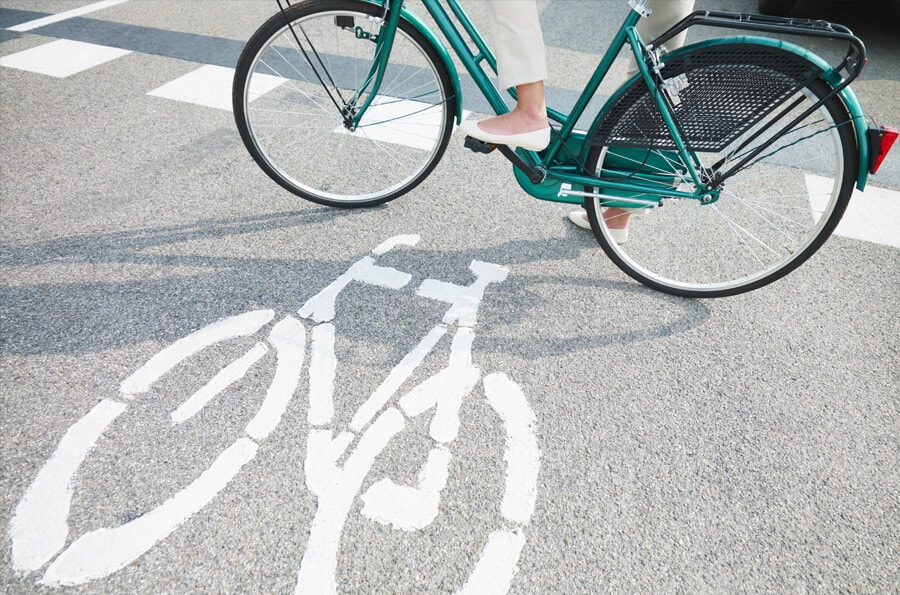 mulher andando de bicicleta verde na ciclovia.