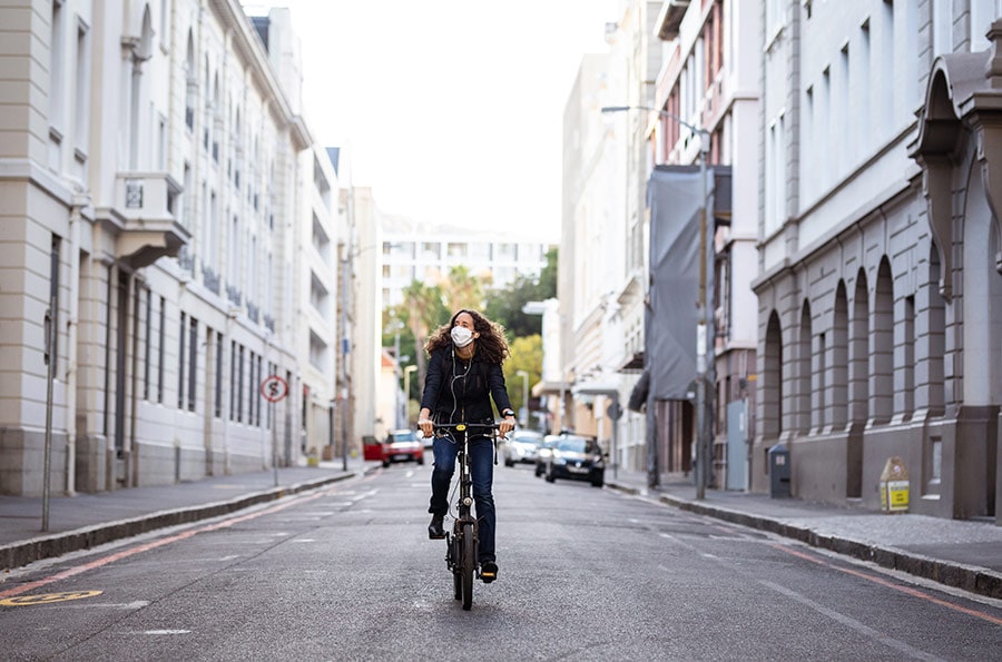 Mulher andando de bicicleta na rua.