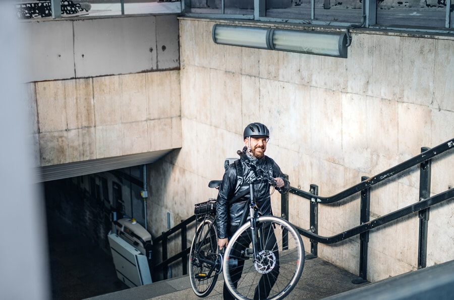 homem saindo do metrô com bike.