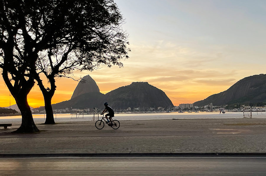 Pessoa andando de bike na praia do Rio de Janeiro.